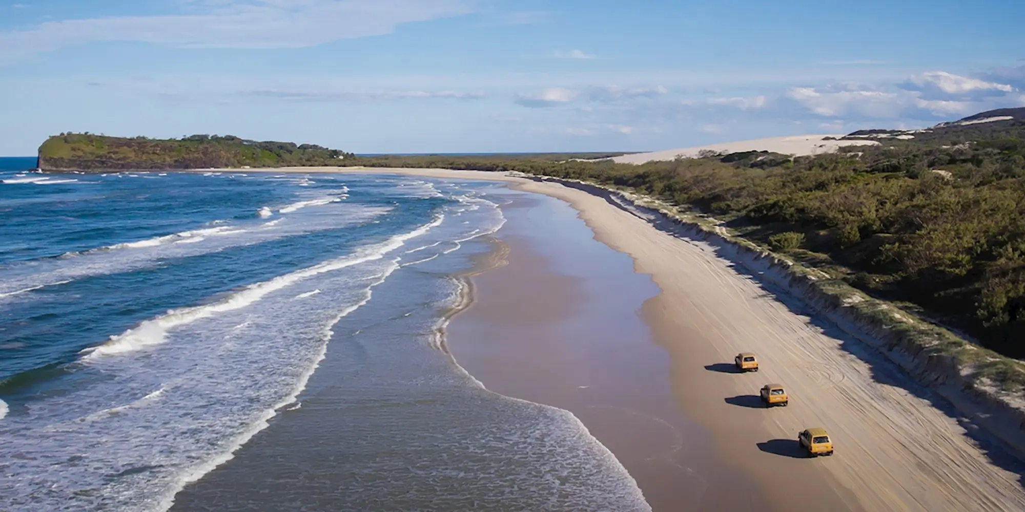 beach scene with the ocean and vehicles